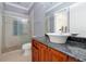 Bathroom with stone countertop, vessel sink, walk-in shower with glass door and decorative tile accent at 1502 Hempel Ave, Windermere, FL 34786