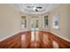 Sunlit bedroom features hardwood floors, a tray ceiling, and French doors to the pool at 1502 Hempel Ave, Windermere, FL 34786