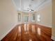 An open bedroom features hardwood floors, a tray ceiling, and glass doors leading to the pool at 1502 Hempel Ave, Windermere, FL 34786