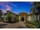 Elegant home featuring a tile roof, stone accents, lush landscaping, and a circular driveway at 1502 Hempel Ave, Windermere, FL 34786