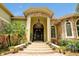 Stately home entrance with stone accents, double doors, chandelier, and manicured landscaping at 1502 Hempel Ave, Windermere, FL 34786