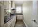 Compact kitchen featuring modern appliances, dark countertops, light cabinetry, and stylish backsplash at 1502 Hempel Ave, Windermere, FL 34786