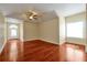 A spacious living room with hardwood floors, a ceiling fan, and natural light from the large window at 1502 Hempel Ave, Windermere, FL 34786