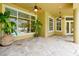 Outdoor patio featuring decorative plants, stone floors, and ceiling fans overlooking the screened pool at 1502 Hempel Ave, Windermere, FL 34786