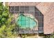 Aerial view of a uniquely-shaped screened pool surrounded by a stone patio and lush landscaping at 1502 Hempel Ave, Windermere, FL 34786