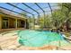 Stunning screened-in pool with stone patio, lush landscaping, and waterfall feature at 1502 Hempel Ave, Windermere, FL 34786
