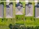 An aerial view shows a green backyard enclosed by a white fence, featuring two young trees at 2044 Keystone Pass Blvd, Minneola, FL 34715