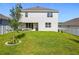 View of the back of a modern home with a covered patio and lush green lawn at 2044 Keystone Pass Blvd, Minneola, FL 34715