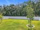 A large backyard with a lush lawn, young trees, and an enclosed white fence at 2044 Keystone Pass Blvd, Minneola, FL 34715