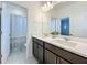 Stylish bathroom with double vanity, modern lighting, and a separate toilet and shower area at 2044 Keystone Pass Blvd, Minneola, FL 34715