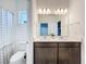 Well-lit bathroom featuring double vanity, modern lighting, and a shower with a patterned curtain at 2044 Keystone Pass Blvd, Minneola, FL 34715