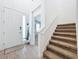 Bright foyer with tile flooring, a white front door, and carpeted stairs leading to the upper level at 2044 Keystone Pass Blvd, Minneola, FL 34715