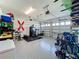 Spacious garage with epoxy floors, overhead storage, and organized workout equipment at 2044 Keystone Pass Blvd, Minneola, FL 34715