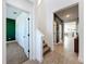 Inviting hallway featuring wood-look tile flooring, stairs, and white trim throughout the home at 2044 Keystone Pass Blvd, Minneola, FL 34715