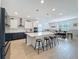 Open kitchen featuring two-tone cabinets, an island with seating, and modern lighting fixtures at 2044 Keystone Pass Blvd, Minneola, FL 34715