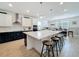 Modern kitchen featuring a large island with seating, stainless steel appliances, and open dining area at 2044 Keystone Pass Blvd, Minneola, FL 34715