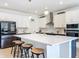 Bright kitchen with white cabinets, a large island, stainless steel appliances, and barstool seating at 2044 Keystone Pass Blvd, Minneola, FL 34715