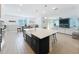 Open-concept kitchen and living area featuring an island with seating and a fireplace at 2044 Keystone Pass Blvd, Minneola, FL 34715