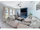 Bright living room with a blue accent wall, fireplace, modern ceiling fan, and lots of natural light at 2044 Keystone Pass Blvd, Minneola, FL 34715