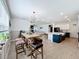 Open-concept living space featuring a dining area, kitchen island, and living room with a fireplace at 2044 Keystone Pass Blvd, Minneola, FL 34715