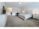 Spacious main bedroom with neutral tones, offering a sitting area and an ensuite bathroom for added convenience at 2044 Keystone Pass Blvd, Minneola, FL 34715