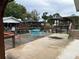 Waterfront backyard featuring a wooden deck with blue patio furniture and access to multiple boat docks at 24505 Snail Rd, Astor, FL 32102