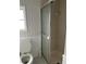 This simple bathroom features a white toilet, tiling, and a standing shower with a sliding door at 24505 Snail Rd, Astor, FL 32102