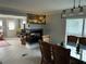 Open dining room showcasing a modern fireplace, glass-top table with wicker chairs, and ample natural light at 24505 Snail Rd, Astor, FL 32102