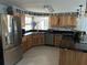 Modern kitchen with stainless steel appliances, wood cabinets, and tile backsplash at 24505 Snail Rd, Astor, FL 32102