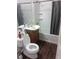 Bathroom features a modern toilet, sleek vanity with sink, and a shower with a rod and curtain for privacy at 2822 S Dean Rd, Orlando, FL 32825