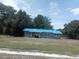 Cozy single-story home with blue roof and gray exterior paint surrounded by mature trees at 2822 S Dean Rd, Orlando, FL 32825