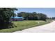 Lovely single-story home with gray paint and a blue tarp roof surrounded by a green lawn and shady trees at 2822 S Dean Rd, Orlando, FL 32825