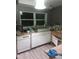 Kitchen features white appliances, light countertops and cabinets, and natural light from a bright window at 2822 S Dean Rd, Orlando, FL 32825