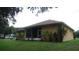 Exterior shot of the home with a screened-in lanai, green lawn, and minimal landscaping at 2913 Deerbrook Dr, Lakeland, FL 33811