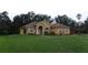 Charming single-story home with a well-manicured lawn, arched entry, and mature landscaping at 2913 Deerbrook Dr, Lakeland, FL 33811