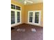 Covered patio with brick floors, white doors, ceiling fan and partial view of the backyard at 2913 Deerbrook Dr, Lakeland, FL 33811