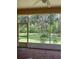 Screened lanai with brick floors, white trim, and a view of the green backyard at 2913 Deerbrook Dr, Lakeland, FL 33811