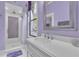 A spacious bathroom shows a glass shower, lavendar accents, and tiled floors at 3450 Ohio Ave, Sanford, FL 32773