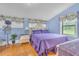 A well lit bedroom shows large windows, purple bedspread, and hardwood floors at 3450 Ohio Ave, Sanford, FL 32773