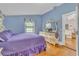 A well lit bedroom features a hardwood floor, window, and a purple bedspread at 3450 Ohio Ave, Sanford, FL 32773