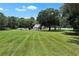 Spacious front yard with a charming home, lush green lawn, and picturesque trees, offering a serene setting at 3450 Ohio Ave, Sanford, FL 32773