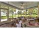 Relaxing screened-in porch with lake views and wicker furniture creates a serene outdoor space at 3450 Ohio Ave, Sanford, FL 32773