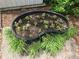 Kidney shaped flower bed with freshly planted flowers, and greenery around it at 360 Kentia Rd, Casselberry, FL 32707