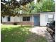Charming single-story home featuring light-colored siding, light blue shutters, a bright blue door, and a well-maintained front lawn at 360 Kentia Rd, Casselberry, FL 32707