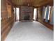 Cozy living room featuring wood-paneled walls, a brick fireplace, and large windows with light-filtering curtains at 360 Kentia Rd, Casselberry, FL 32707
