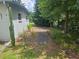 Side yard of home shows landscaping and walkway. The property has a neutral color palette and mature trees at 360 Kentia Rd, Casselberry, FL 32707