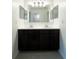Bright bathroom featuring double sinks and dark cabinetry at 3850 Hampstead Ln, Lakeland, FL 33810