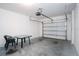 Spacious garage with concrete floor and an automatic garage door opener; includes a table and chair set at 3850 Hampstead Ln, Lakeland, FL 33810