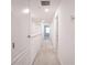 Carpeted hallway with neutral walls, leading to a room with natural light at 3850 Hampstead Ln, Lakeland, FL 33810