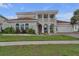 Stunning two-story home with a tile roof, columns, and a well-manicured lawn and garden at 3869 Shoreside Dr, Kissimmee, FL 34746